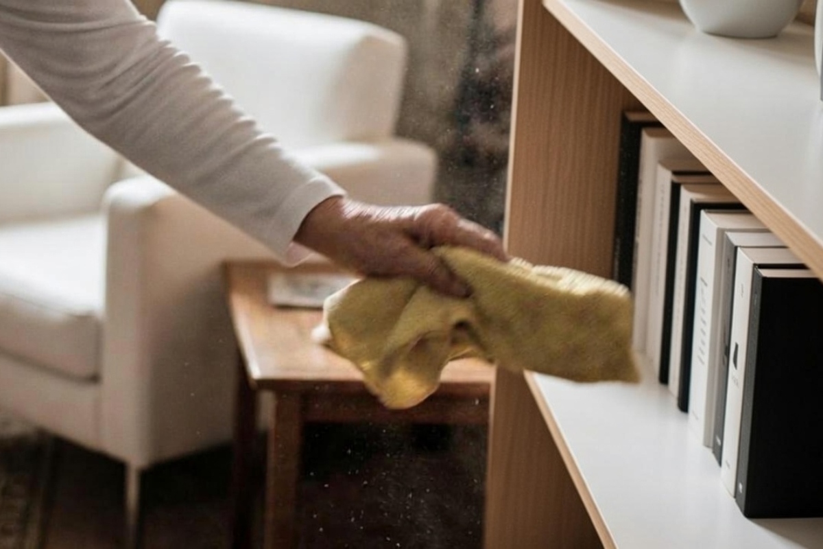 Dust being wiped from a bookshelf